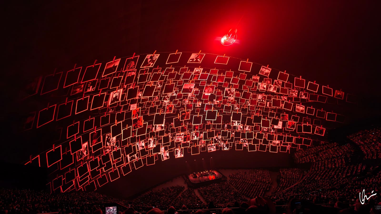 Sphere dome in red light: hundreds of photos on clothespins and a giant glowing light bulb above the hall
